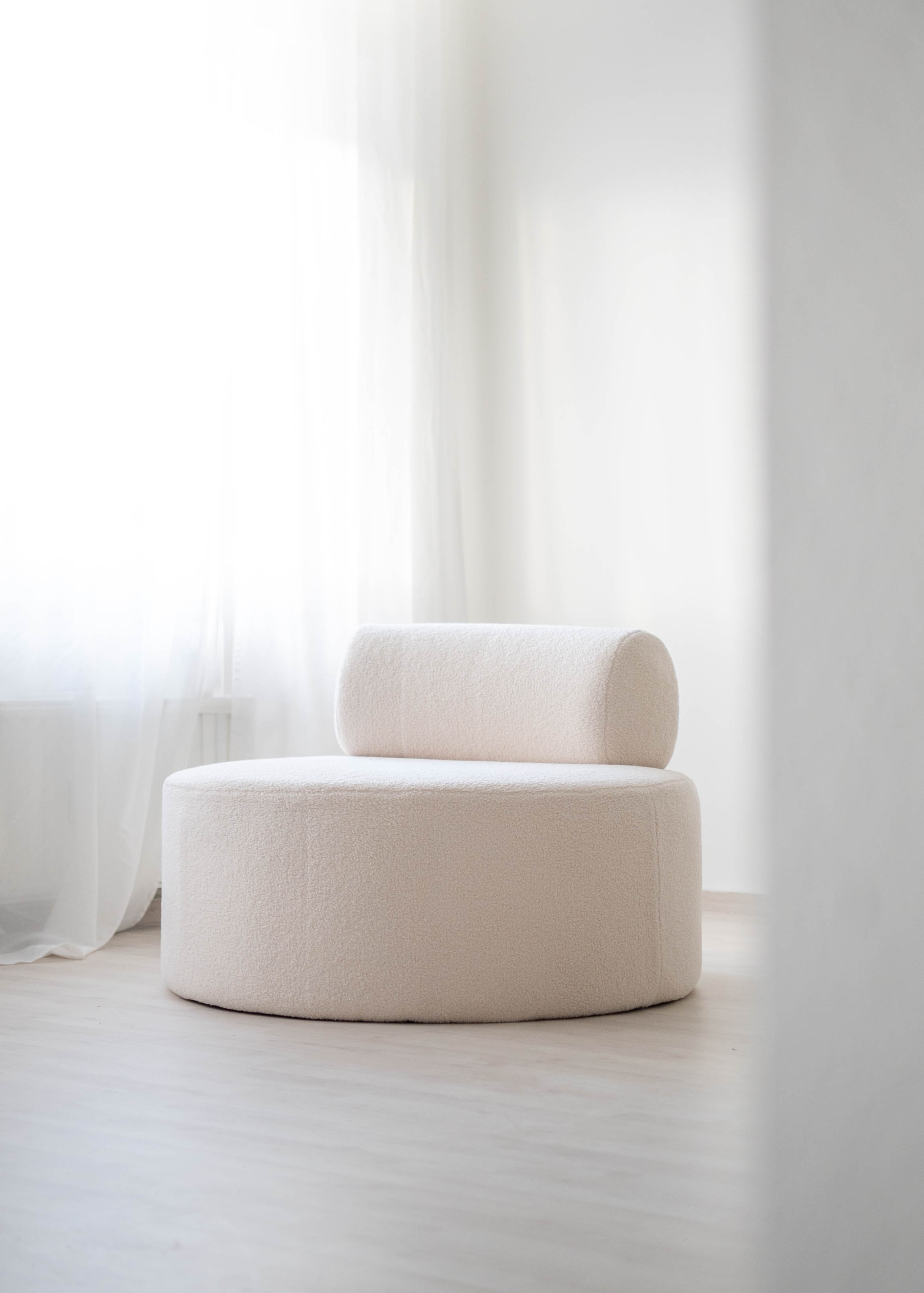 Weißer Lounge-Sessel im hellen Studio